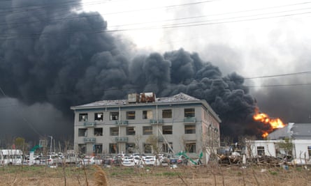 Smoke billows from fire behind a damaged building following an explosion at the pesticide plant in Yancheng.