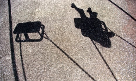 The shadow of a young girl or boy playing on a swing.