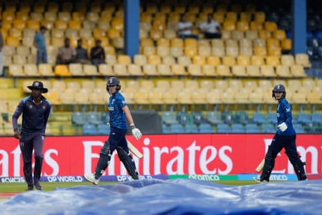 England’s Charlie Dean and Em Arlott walk off the field as it rains