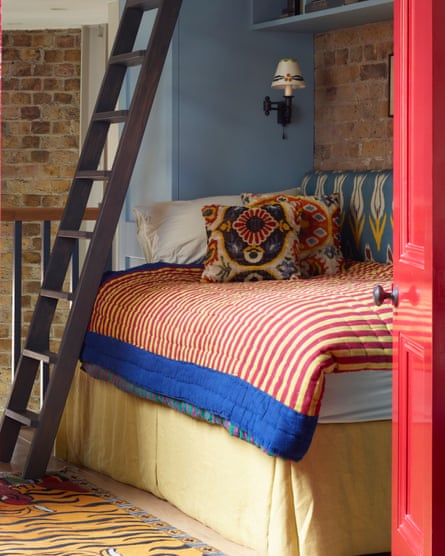 The guest bedroom has a ladder up to a mezzanine area used for storage, as well as a study with built-in desk.