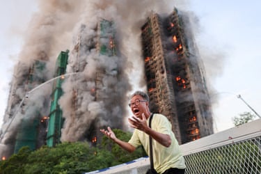 Mr Wong cries out in anguish as fire engulfs the Tai Po housing complex behind him