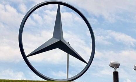 Very large metal Mercedes Benz symbol, a three-pointed star inside a circle, under partly cloudy sky.