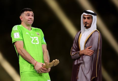 Emi Martinez receives his golden glove award after the World Cup final.