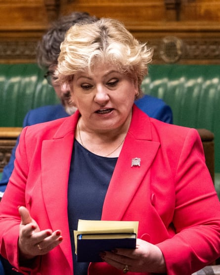 Emily Thornberry speaks in the House of Commons: she has blond hair and wears a bright red jacket over a black top. She is reading from paper notes held in one hand.