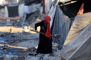 A woman cleans an area next to tents in Gaza City