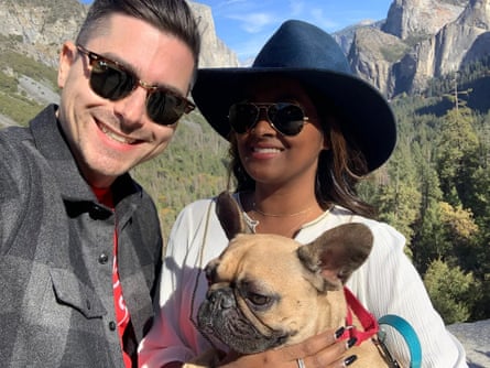 Adrian holds Walter as they pose for a photo alongside Paul, with mountains behind