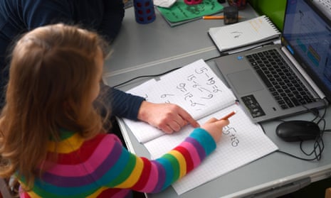 Young girl in colourful jumper doing maths in front of computer