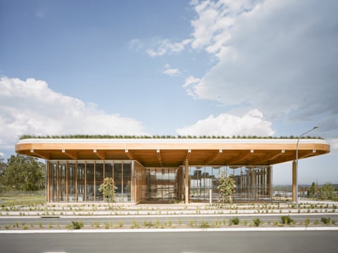 Bradfield City Centre, a flat wooden building with lots of beams and windows under a bright but cloudy sky.