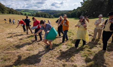 Fiddle group play as people scatter seeds in meadow