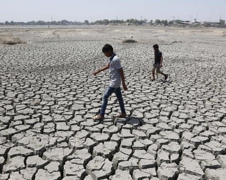 Two boys walk through a dried up Chandola Lake in Ahmadabad, India, May 2016