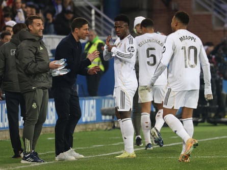 Real Madrid's Kylian Mbappe celebrates scoring their first extremity arsenic coach Xabi Alonso gives instructions to Vinicius Junior