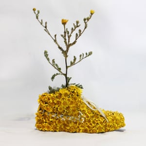A trainer sculpture with flowers created by artist Christophe Guinet