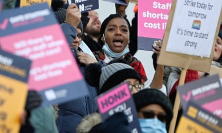 NHS nurses in London hold banners during a strike.