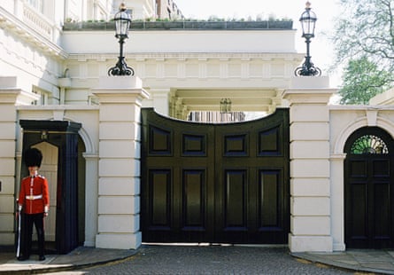 Guard standing outside a black gate to Clarence House