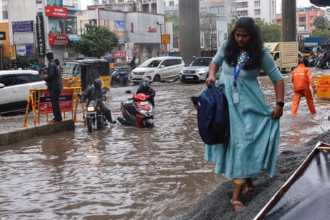 People commute through a water-logged street in Chennai, India.