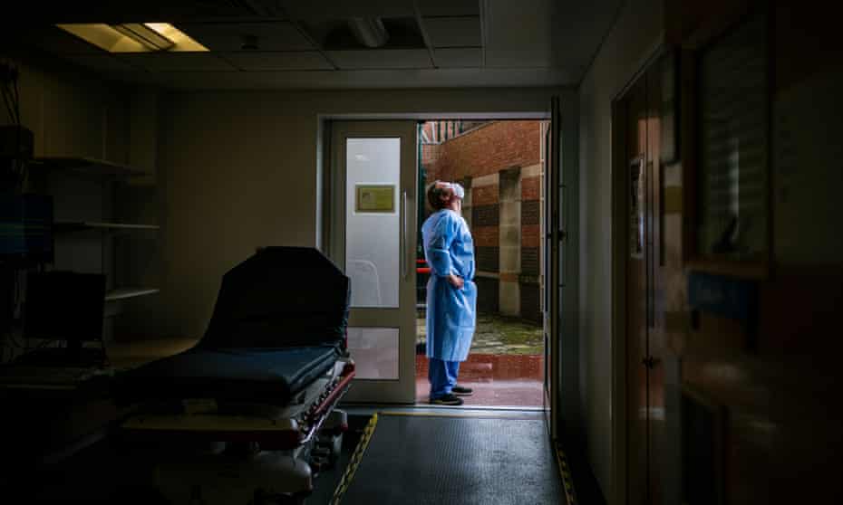 A domestic caretaker takes a breath of fresh air and feels the rain on his face outside the paramedic's entrance of the triage area in a hospital emergency department