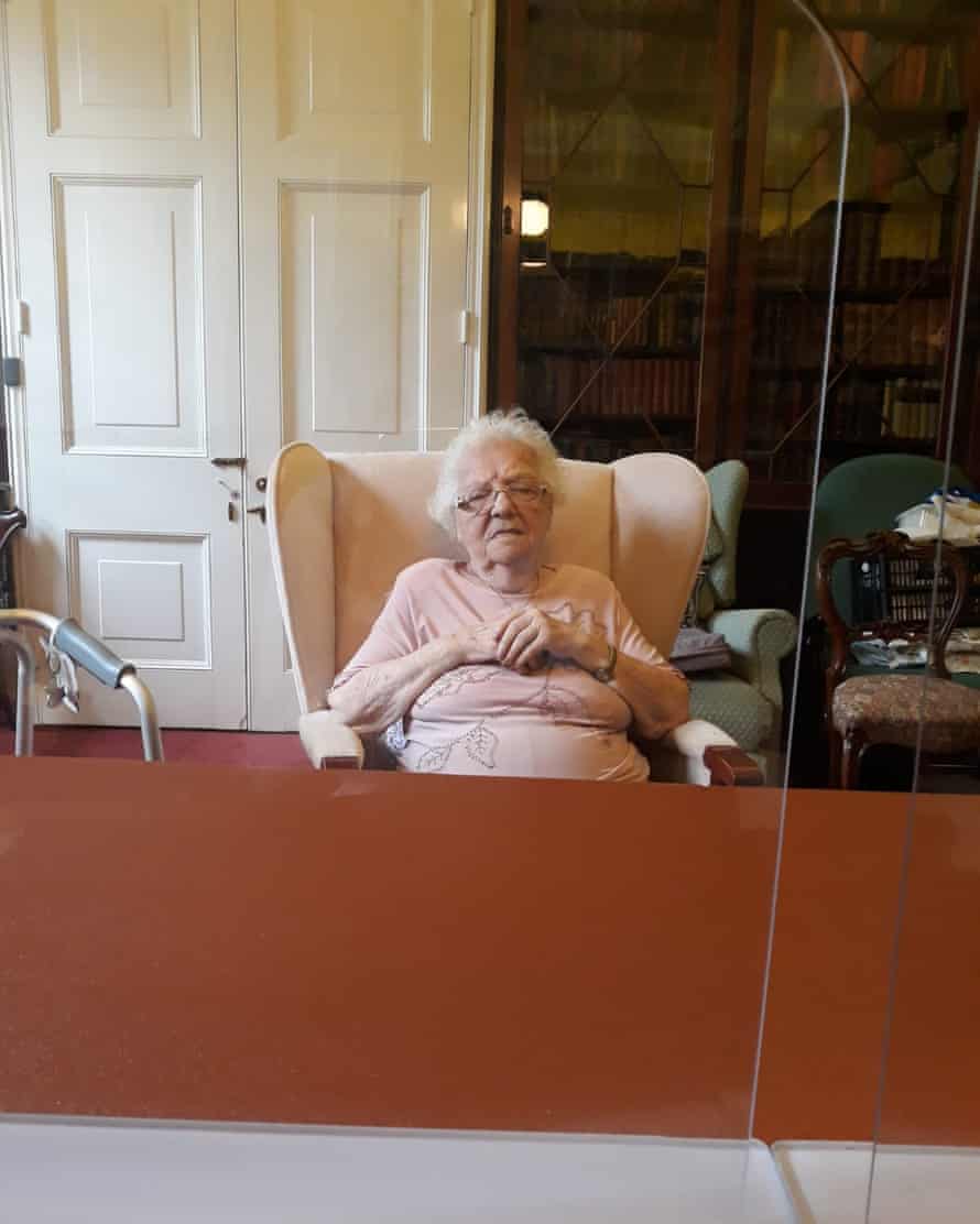 Eve behind a perspex screen in her care home in a photo taken by her daughter.
