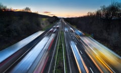 Light trails of fast-moving cars on busy motorway at dusk