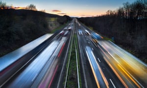 Light trails of fast-moving cars on a busy motorway at dusk