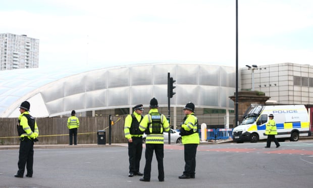 Police officers stand at the Miller Street and Corporation Street crossroads in front of the Manchester Arena.