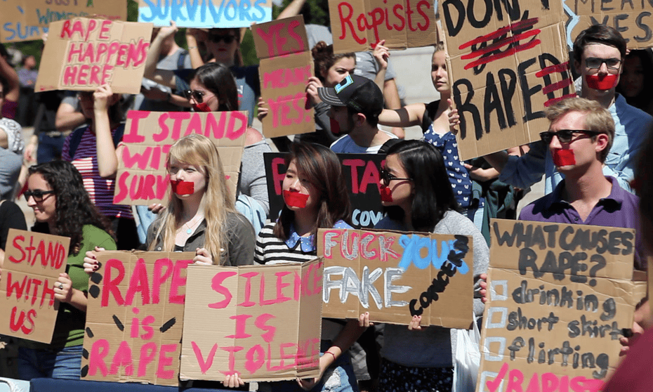 Students holding signs saying, 'rape is rape', and 'silence is violence'. A scene from the 2015 documentary The Hunting Ground