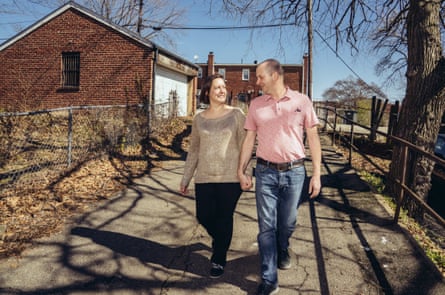 Katie McCaskey and Brian Wiedemann walking down a path, with a garage on one side, a tree on the other and a house behind them