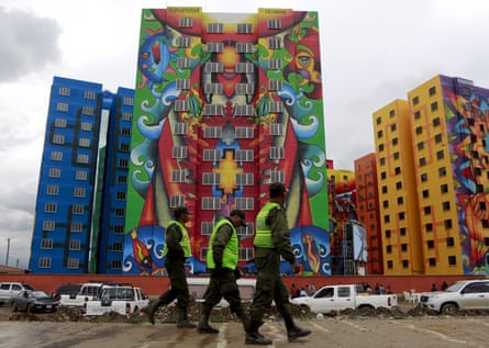 Police officers pass a housing programme in El Alto.