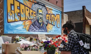 A woman places flowers at a memorial for George Floyd in Minneapolis, Minnesota, on 31 May.