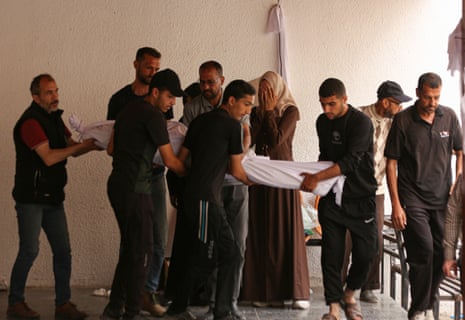 The body of a Palestinians killed by an Israeli airstrike is brought to the morgue of al-Ahli Baptist hospital in Gaza City.