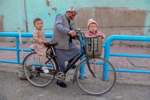 Kabul, AfghanistanA man and his children alight their bicycle.
