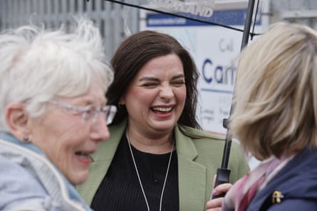 Loudon holds umbrella as she laughs with two women