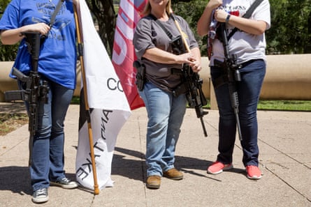 Demonstrators open-carry rifles while holding flags during a pro-gun rally on the sidelines of the National Rifle Association annual meeting in Dallas, Texas, on 5 May 2018.