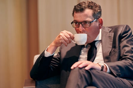Dan Andrews seated drinking from a white cup