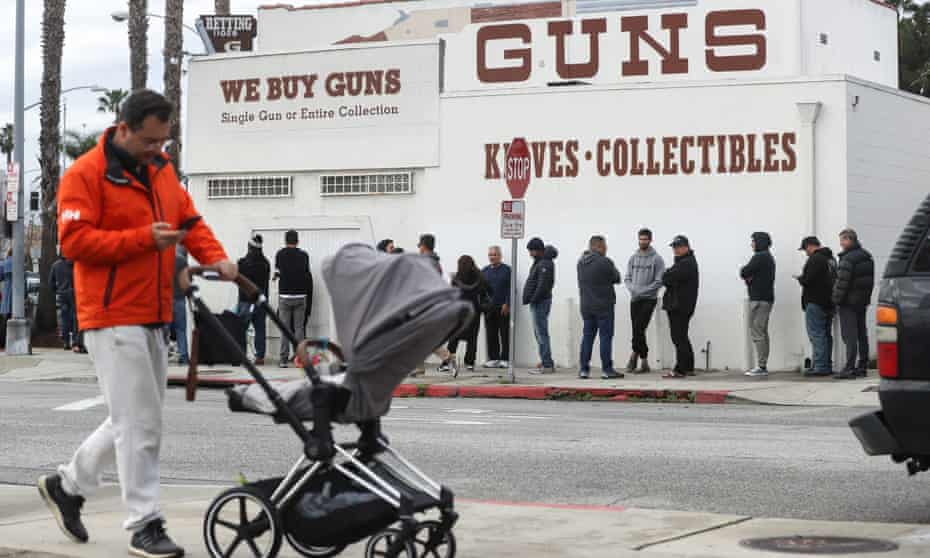 People stand in line outside the Martin B Retting, Inc guns store in Culver City, California. The spread of Coronavirus has prompted some Americans to line up for supplies in a variety of stores.