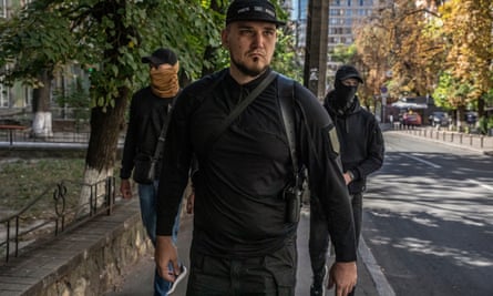 Denis Nikitin flanked by two armed bodyguards in Kyiv. He is the head of the Russian Volunteer Corps, a controversial unit of Russian citizens that fights alongside the Ukrainian army.