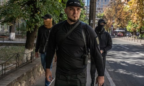 Denis Nikitin flanked by two armed bodyguards in Kyiv.