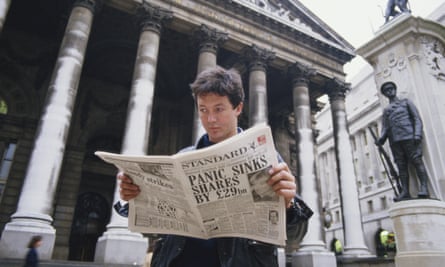 A young man reads a copy of the Evening Standard, with a headline referring to that day’s stock market crash, known as Black Monday, 19 October 1987
