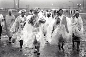 Women workers wearing rain capes returning to their camp in Botshabelo, South Africa, 1990