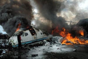 Goma, Congo: A man tries to put out the final flames that engulfed the remains of a plane crash
