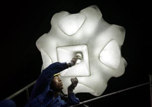 Beijing, China: A worker changes a lightbulb in the National Stadium