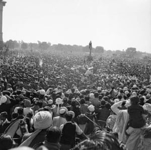 A huge crowd awaits the arrival of the funeral procession bearing the body of Mohandas Gandhi