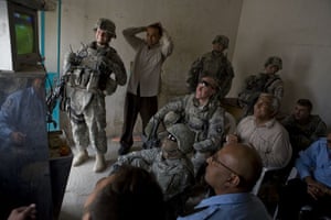 American soldiers and Iraqi police watch a football match between Australia and Iraq. 