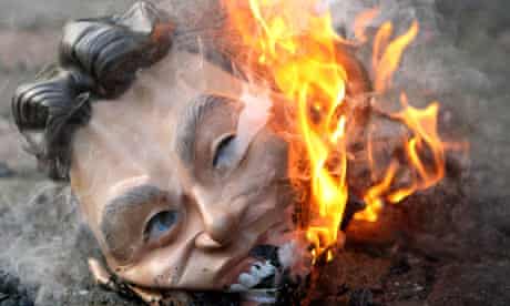 A demonstrator burns a mask of Tony Blair outside the Chilcot Iraq inquiry