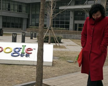 A Chinese woman walks past the Google logo at the Google China headquarters in Beijing, China
