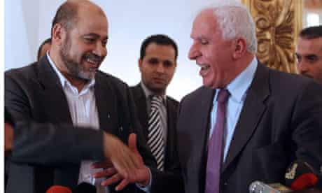 Hamas' Musa Abu Marzuka and Fatah Azzam al-Ahmad shake hands