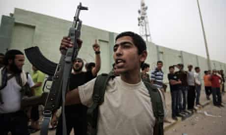 Libyan rebels cheer with their weapons as comrades advance to Brega