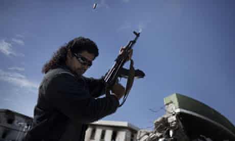 A Libyan armed man shoots in the air