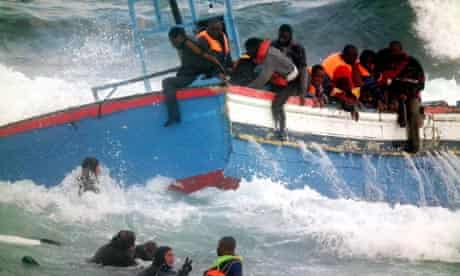 Rescuers help Libyan migrants who fled to the Italian island of Pantelleria i
