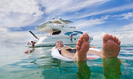 A man swimming off his luxury yacht