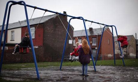 children by swings in rain on housing estate